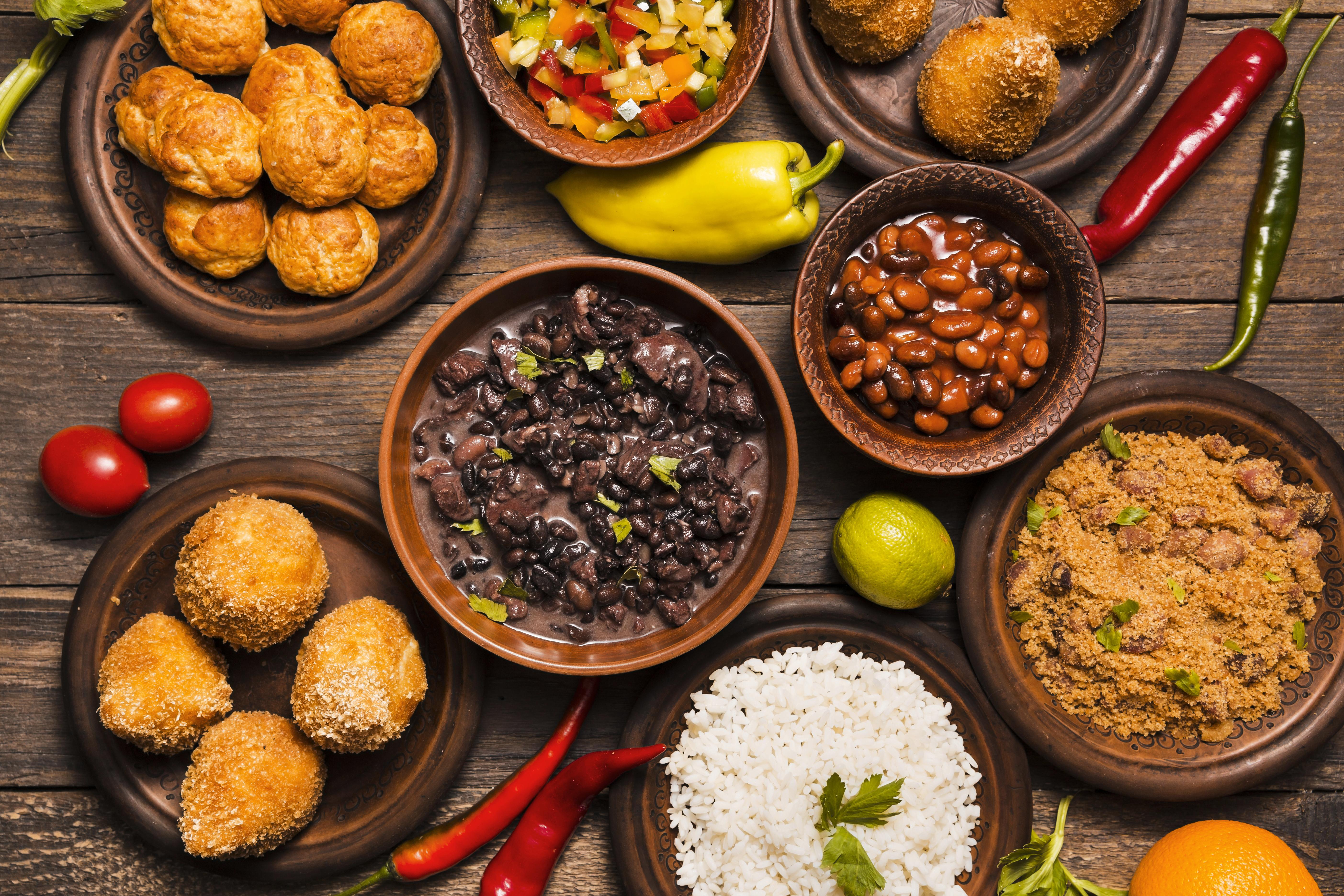 Imagem de comida brasileira em pratos em cima da mesa